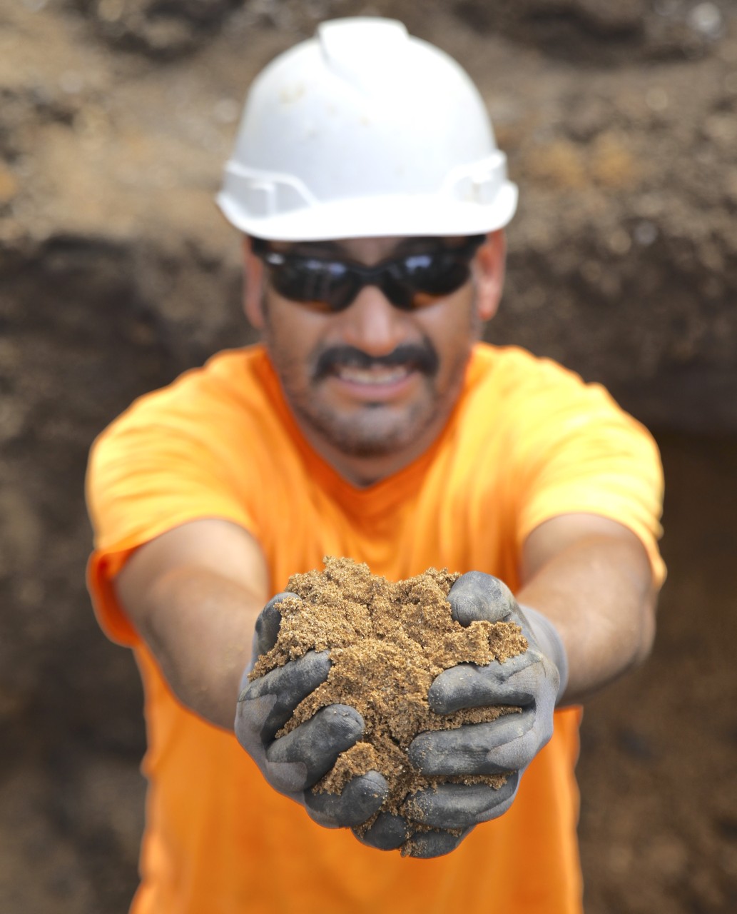 A worker showing excavated soil during lead service line replacement.